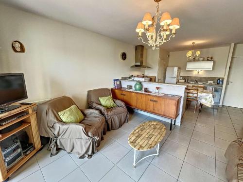 un salon avec un canapé et une télévision dans l'établissement Appartement PMR avec Terrasse au Cœur de Granville, Proche Plage et Port - FR-1-361-508, à Granville