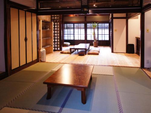 a living room with a wooden table on the floor at （一棟貸切）町家体験ゲストハウス「ほんまちの家」〜高岡市の伝統的な古民家～ in Yokota