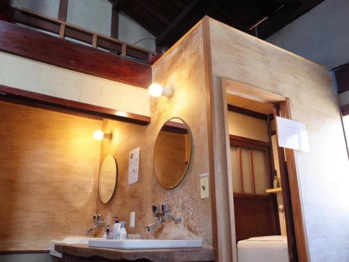 y baño con lavabo y espejo. en （一棟貸切）町家体験ゲストハウス「ほんまちの家」〜高岡市の伝統的な古民家～, en Yokota