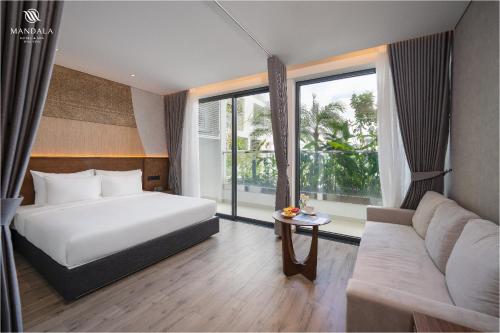 a hotel room with a bed and a couch at M Continental by Mandala Phu Yen in Liên Trì (3)