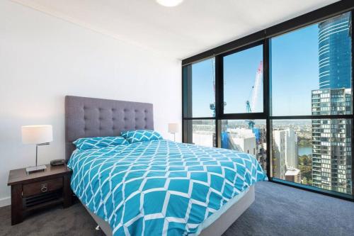 a bedroom with a bed and a large window at 37F Brisbane CBD Apartment with City Views and Pool in Brisbane