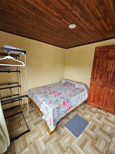 a small bedroom with a bed and a wooden ceiling at Aves del Paraíso in Tilarán