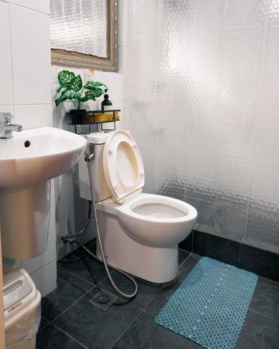 a bathroom with a white toilet and a sink at 87 Guesthouse in Baguio