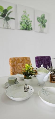 una mesa blanca con platos y tazones. en Sky Garden HomeStay, Presint 15 Putrajaya, en Putrajaya