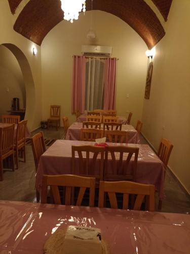a dining room with tables and chairs with pink table cloth at Rahala Safari Hotel in Qasr Al Farafirah