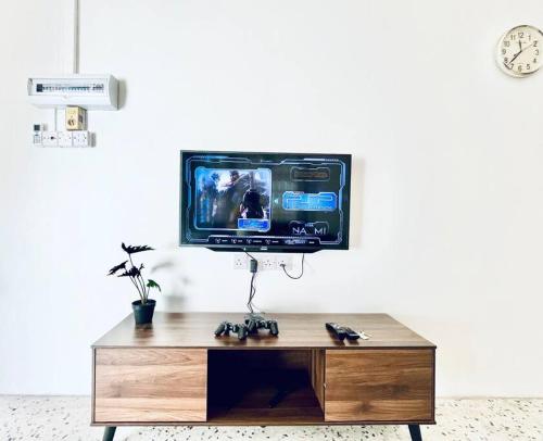 a tv sitting on top of a wooden table at Gioia2Home 5 mins to Taiping/Kamunting in Taiping