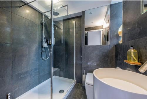 a bathroom with a shower and a tub and a sink at Stunning 3 bedroom, 3 bathroom duplex with terrace in London