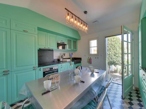 une cuisine avec des placards verts et une table avec des chaises dans l'établissement Charmante Villa 4 pièces, 6 pers. au Quartier du Casino de Châtelaillon-Plage, proche mer, jardin, parking - FR-1-706-15, à Châtelaillon-Plage