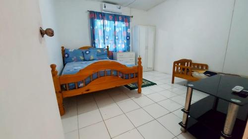 1 dormitorio con cama de madera y mesa en Mackenzie Guest House en Clifton