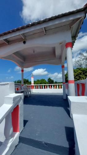 a pavilion with red and white columns and a lighthouse at Holiday rooms in St Thomas Jamaica in Clifton
