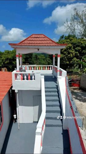 a building with a gazebo with stairs and a roof at Holiday rooms in St Thomas Jamaica in Clifton