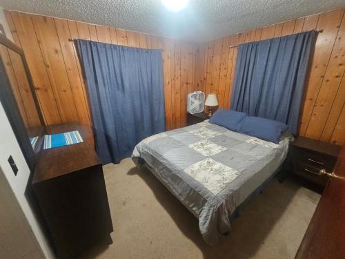 a bedroom with a bed with blue drapes at Downtown Aurora house #1 in Fairbanks
