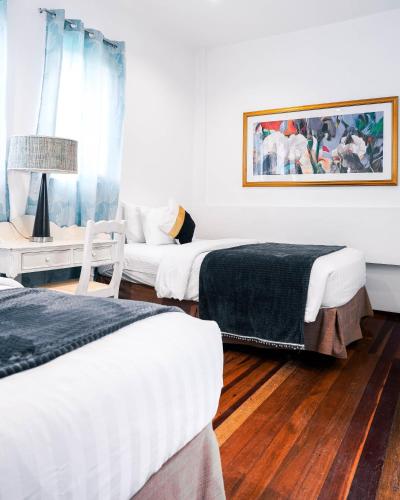 a bedroom with two beds and a couch in it at 87 Guesthouse in Baguio