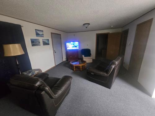 a living room with two leather chairs and a television at Downtown Aurora house #1 in Fairbanks