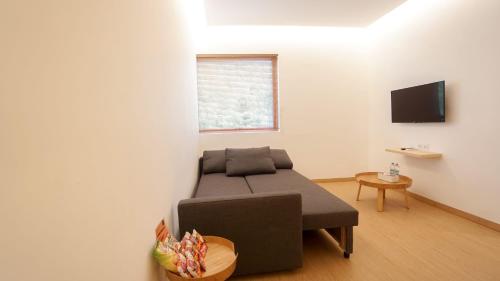 uma sala de estar com um sofá e uma televisão em ManukabyHavis Boutique Hotel em Nagoya