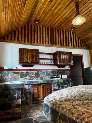 a bedroom with a bed and a stone wall at Mai Pen Rai Bungalows in Than Sadet Beach