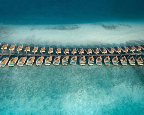 an aerial view of a resort with chairs and the ocean at Finolhu Baa Atoll Maldives in Baa Atoll