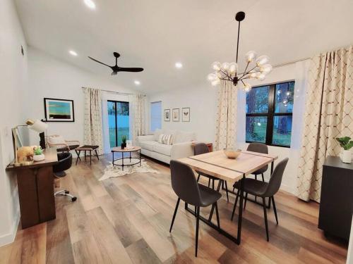 Un comedor y una sala de estar con mesa y sillas. en Elegant Cozy Spot to unwind! UCF/MCO/Parks/Beach, en Orlando
