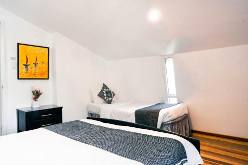 a bedroom with two beds and a window at 87 Guesthouse in Baguio