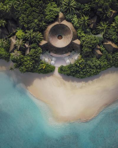 an aerial view of a beach and the ocean at Finolhu, A Seaside Collection Resort, a Member of Design Hotels in Baa Atoll