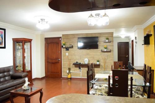 a living room with a couch and a tv on a wall at Hermoso apartamento en el centro de Ipiales in Ipiales