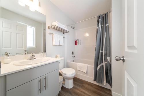 a white bathroom with a sink and a toilet at Single detached house with 3 BRM in Edmonton