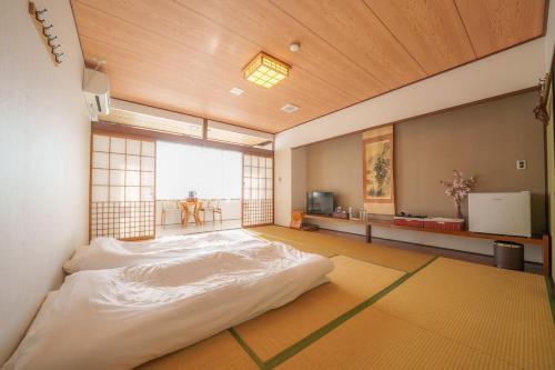 a bedroom with a large white bed in a room at Fuji Yamanakako Resort Hotel in Yamanakako