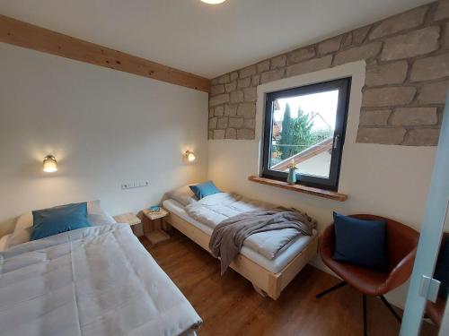 a bedroom with two beds and a window at Ferienwohnung Am Eselsburger Tal in Herbrechtingen