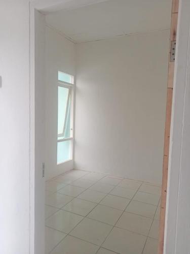 an empty room with a window and a white wall at Permata Homestay in Karawang