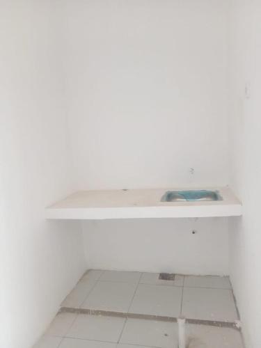 Permata Homestay في كراوانغ: رف أبيض في غرفة بيضاء مع أرضية بلاط