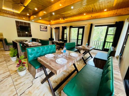 a dining room with tables and green chairs at Hotel Forest View Dalhousie, Banikhet in Dalhousie