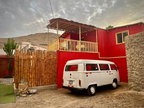 uma carrinha branca estacionada em frente a uma casa vermelha em La Casa Roja Cerro Azul em Cerro Azul