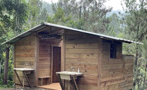 a small wooden building with two sinks in it at Spirit Mountain Coffee in Manabao