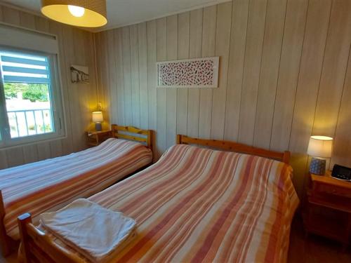 une chambre avec deux lits et une fenêtre dans l'établissement Bel Appartement Face Mer - 1 Chambre - Classé 2* - Parking - 5 personnes - FR-1-323-299, à Saint-Jean-de-Monts