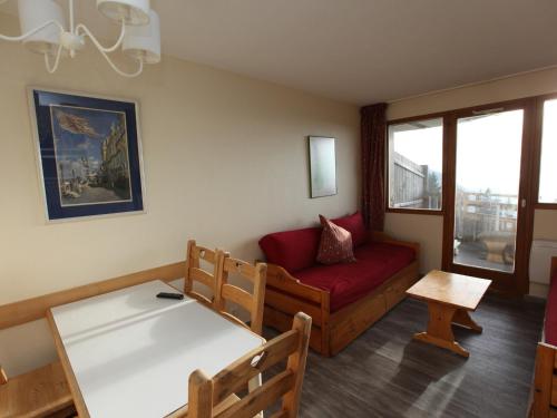 a living room with a red couch and a table at Appartement Avoriaz, 2 pièces, 5 personnes - FR-1-314-268 in Morzine