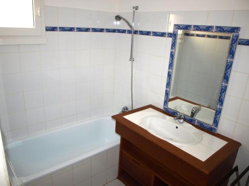 une salle de bain avec un lavabo, une baignoire et un miroir dans l'établissement Maison à Saint-Jean-de-Monts avec Piscine Chauffée, proche Plage et Commerces - FR-1-323-377, à Saint-Jean-de-Monts
