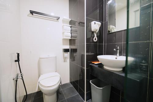 a bathroom with a white toilet and a sink at The Concept Hotel Melaka City in Melaka