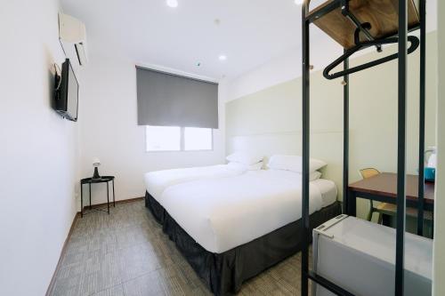 1 dormitorio con 1 cama y 1 litera en The Concept Hotel Melaka City en Melaka