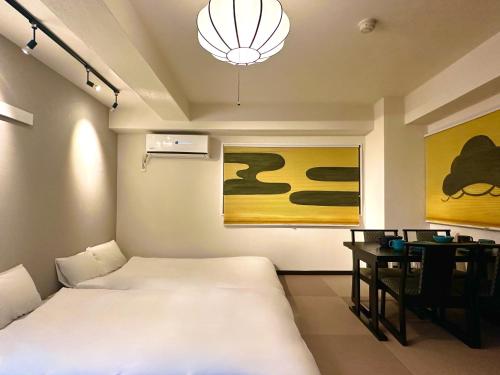 a bedroom with two beds and a desk and a lamp at LOVE UENO 2-4人アクセス抜群 山手線3分 上野浅草銀座近い 御徒町駅3分 アメ横3分 上野駅10分 上野広小路駅3分 湯島駅2分 和風畳寝室 in Tokyo