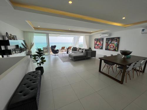 a living room with a table and a couch at The Beach Residence in Koh Samui