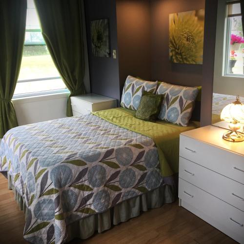 a bedroom with a bed and a window at Gîte du Moulin in L'Isle-aux-Coudres