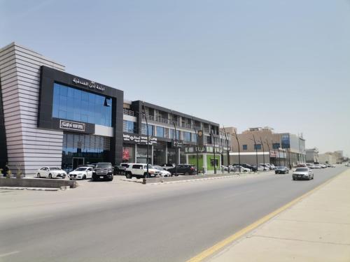 a street with cars parked in front of a building at Sokon Ladn Hotel in Riyadh