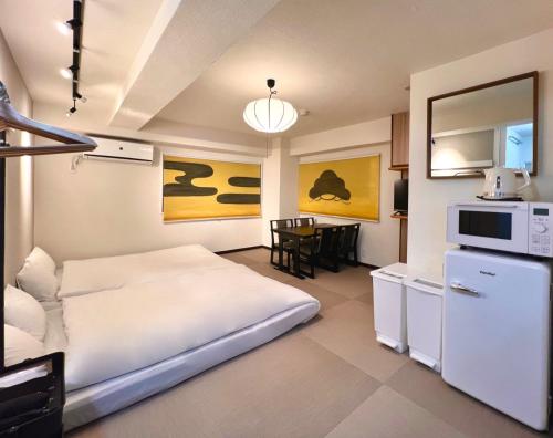 a hotel room with a bed and a kitchen at LOVE UENO 2-4人アクセス抜群 山手線3分 上野浅草銀座近い 御徒町駅3分 アメ横3分 上野駅10分 上野広小路駅3分 湯島駅2分 和風畳寝室 in Tokyo