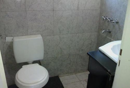 La salle de bains est pourvue de toilettes blanches et d'un lavabo. dans l'établissement quinta el ensueño, à General Rodríguez