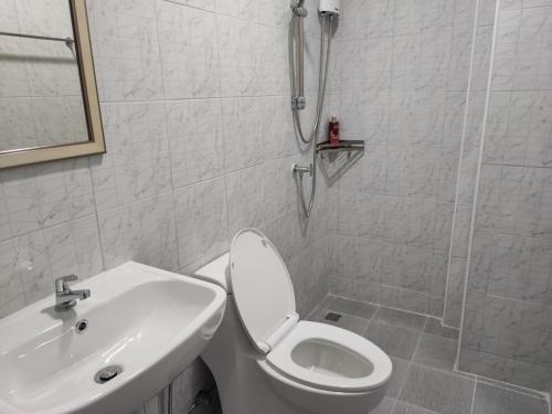 a white bathroom with a toilet and a sink at Phenn's House @Ramkhamhaeng in Bang Kapi