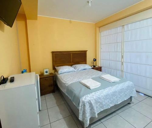1 dormitorio con 1 cama con 2 toallas en CASA DE PLAYA CON PISCINA PUNTA NEGRA en Punta Hermosa