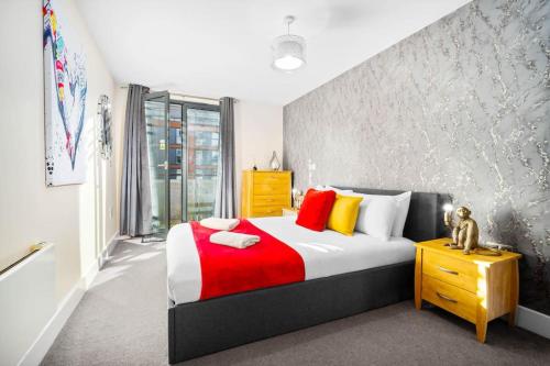a bedroom with a large bed with red and yellow pillows at Modern Arcadian Center Apartment By Azura Nights in Birmingham