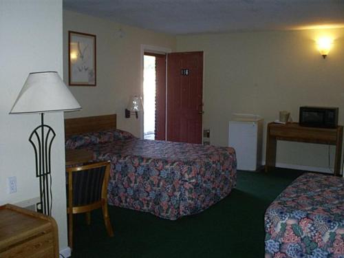 a hotel room with two beds and a lamp at Crestview Inn in Crestview