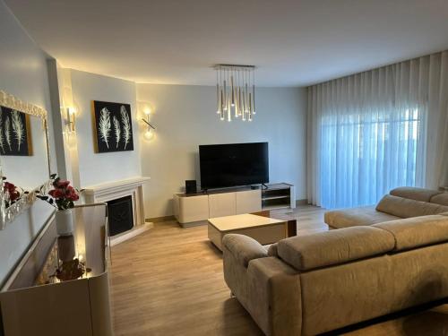 a living room with a couch and a television at Peaceful Retreat Leiria in Marinha Grande