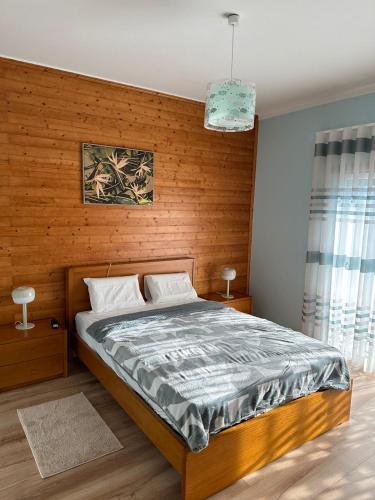 a bedroom with a bed with a wooden wall at Peaceful Retreat Leiria in Marinha Grande